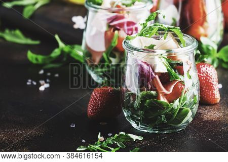 Fresh Salad With Spicy Arugula, Goat Cheese, Strawberry And Prosciutto Or Ham In Modern Glass Jars O