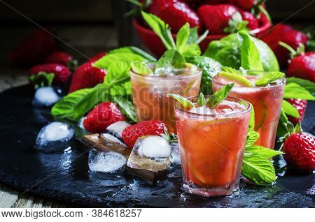 Alcoholic Cocktail Strawberry Mojito With White Rum, Syrup, Soda, Lime, Mint And Ice, Black Backgrou