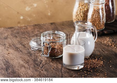 Vegan Buckwheat Plant Based Milk In Bottles, Closeup, Brown Background. Non Dairy Alternative Milk. 