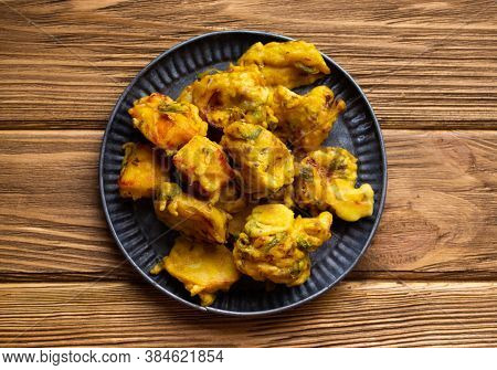 Indian Fried Assorted Pakoras On Wooden Rustic Background. Traditional Indian Mixed Vegetable Crispy