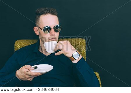 Business Man Sitting In A Chair And Drinking Coffee, Tea.