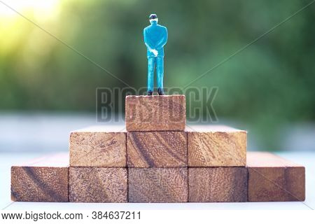 Model Of A Business Man That Rises To The Highest Point. The Winner Concept