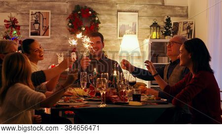 Cheerful Family With Different Ages Holding Sparkles Celebrating Christmas. Happy Family. Winter Hol