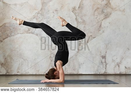 Strong Woman Practicing Yoga, Doing Pincha Mayurasana Exercise, Doing Handstand Pose, Working Out In