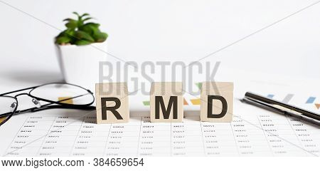 Rmd Word Concept Written On Wooden Blocks, Cubes On A Table With Flower ,pen And Glasses On Chart Ba