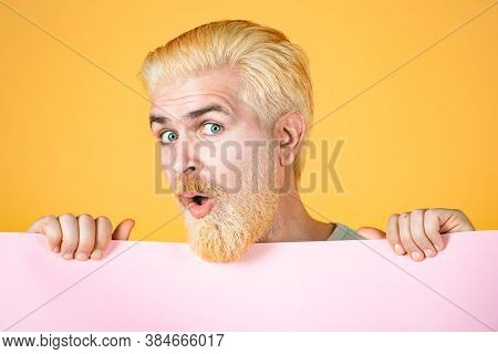 Man Holding Big Sign Board. Copy Space On Paper. Man Holding Empty Sheet Of A Paper. Colorful Studio