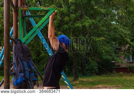 Athlete Doing Pull-up On Horizontal Bar. Male Sportsman Doing Fitness Exercises On Playground Outdoo