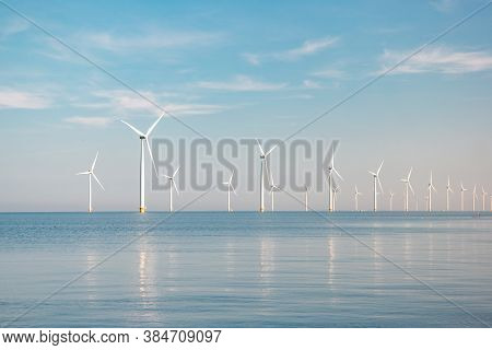Offshore Windmill Park With Stormy Clouds And A Blue Sky, Windmill Park In The Ocean
