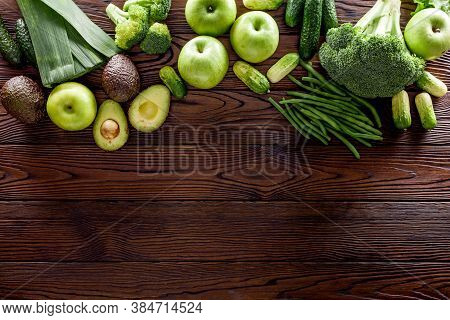 Green Vegetables Background. Сucumber, Avocado, Broccoli, Beans, Leek And Fresh Apple On Dark Wooden