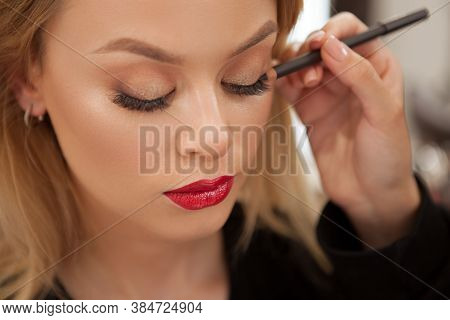 Close Up Of A Professional Makeup Artist Lining Eyes Of A Beautiful Woman With Kajal