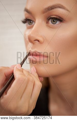 Vertical Close Up Of A Woman Having Her Lips Contoured By Professional Makeup Artist