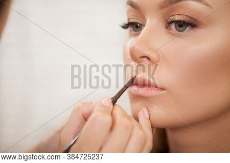 Close Up Of A Beautiful Woman Having Her Lips Painted By Professional Makeup Artist