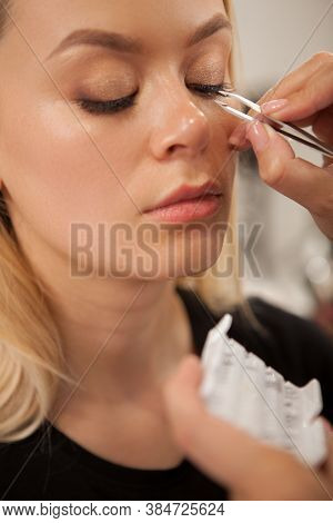 Vertical Close Up Of A Beautiful Woman Getting False Lashes Glued By Professional Makeup Artist