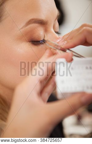 Vertical Close Up Of A Woman Getting False Eyelashes Applied By Professional Makeup Artist
