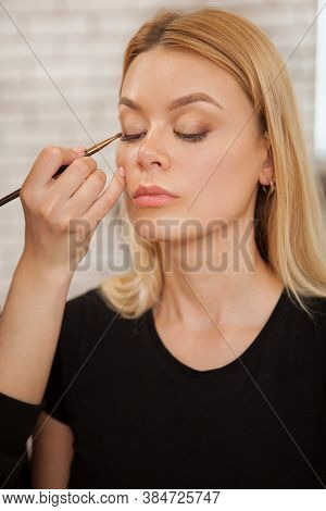 Vertical Shot Of A Professional Makeup Artist Working At Beauty Studio, Preparing Female Model For P