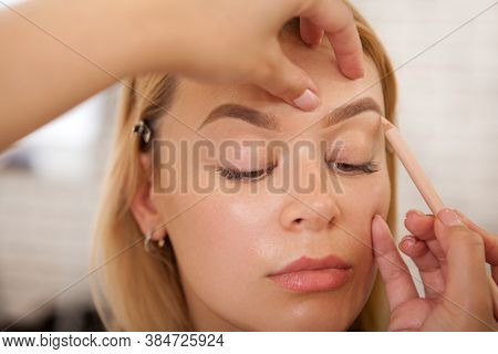 Cropped Shot Of A Makeup Artist Using Brow Pencil On A Female Client