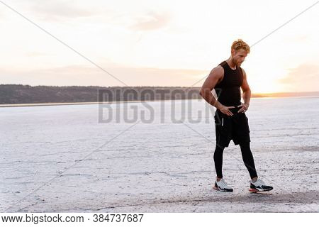 Image of caucasian athletic sportsman standing while working out on nature