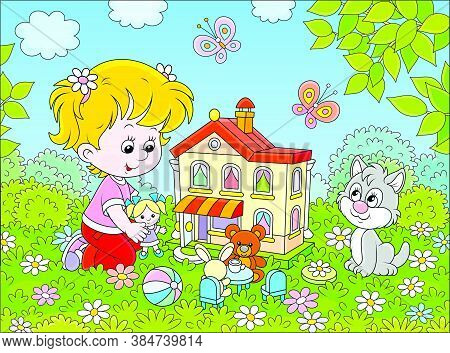 Cute Little Girl Playing With A Small Doll, A Bear, A Rabbit And A Toy House Among Flowers On A Sunn