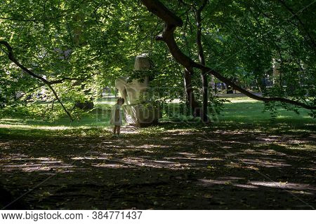 Gdansk, North Poland - August 13, 2020: A Little Girl Standing Alone Under A Shade In Park Exploring