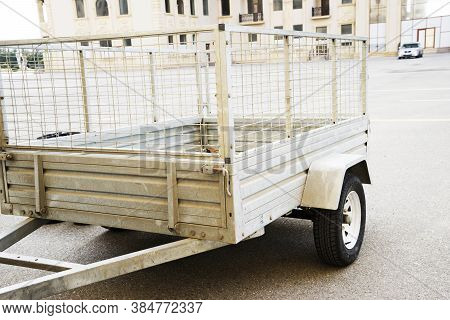 Car Trailer. Car Trailer With Two Wheel Axle, Loaded Silver Car Trailer At The Storage Place In A Co