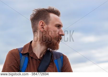 Handsome Hipster Man With Lush Beard And Mustache On Blue Sky Background. Red Bearded Guy. Serious B