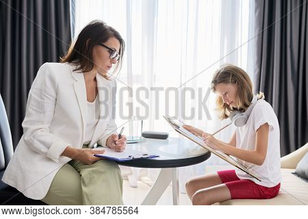 Child Psychologist Talking To Girl Kid In Office. Psychology, Psychotherapy, Professional Counseling