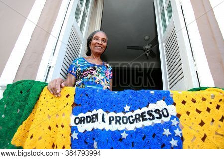 Salvador, Bahia / Brazil - July 2, 2015: Person Holds Brazilian Flag In The Lapinha Neighborhood Of 
