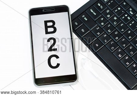 Text B2c On Phone Screen Lying On Laptop Keyboard