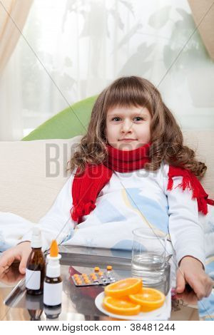 Bambina malata con sciarpa a letto è prendere Medicine