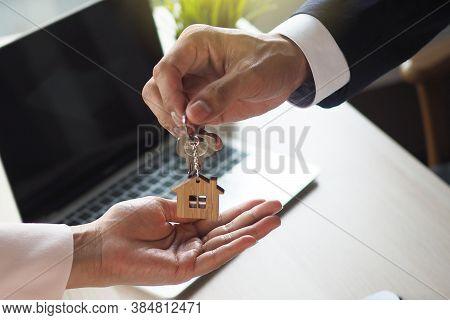 Tenant With The Landlord. Home Salesmen Are Looking At Home Keys To Buyers According To A Rental Agr