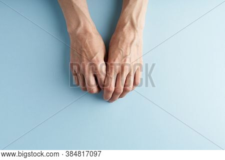 Hard-working Hands With Protruding Veins On Blue Background.
