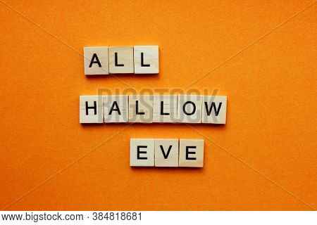 Words All Hallow Eve. Wooden Blocks With An Inscription On An Orange Background. Bulletin Board. The