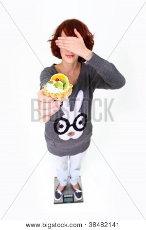 MÃ¤dchen auf der Waage steht, hÃ¤lt einen Kuchen und schlieÃŸen ihre Augen, isolated on white background
