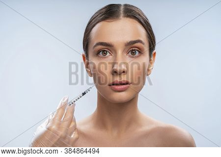 Beautiful Dark-haired Lady Doing A Cosmetic Procedure