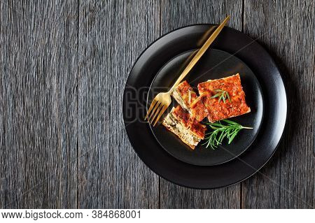 Piece Of Lasagna With Champignon And Tomato Vegetarian Bolognese Served On A Black Plate With Fork A