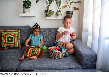 Young Girls Knitting, Its An Old Fashioned Hobby That They Love To Do In Lockdown. Children Knit Cro