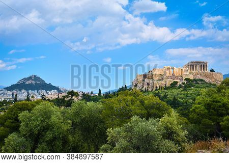 Iconic Vew Of Acropolis Hill And Lycabettus Hill In Background In Athens, Greece From Pnyx Hill In S