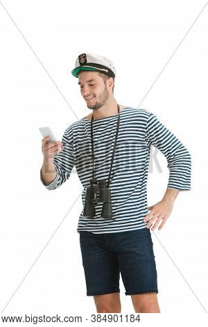 Scrolling Phone. Caucasian Male Sailor In Uniform On White Studio Background. Young Man Using Modern