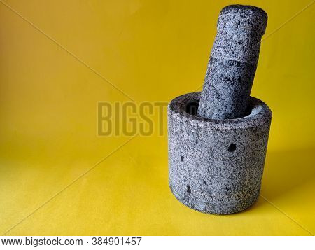 Mortar And Pestle Set Made Of Stone. Isolated On Yellow Background. Copy Space