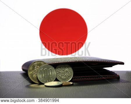 Pile Of Japanese Yen Coins (jpy) On Black Floor With Black Wallet And Flag Background, The Concept O