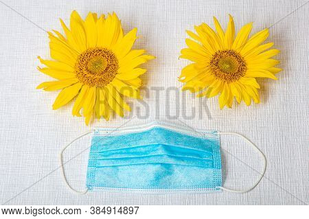 Two Sunflower Flowers And A Medical Mask, Concept During Coronavirus Protecti Seya And Loved Ones. H