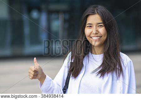 Female Asian Ethnic Businesswoman Laughing, Smiling Wide With White Teeth And Showing A Finger Gestu