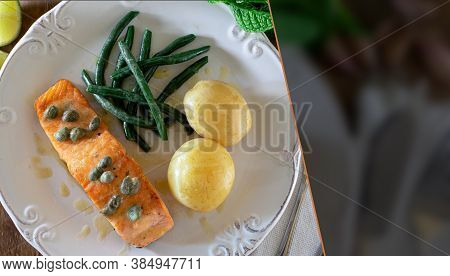 Grilled Salmon Fillet With Caper Sauce, Potatoes, Garlic, Parsley And Green Beans. Selective Focus. 