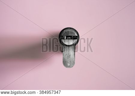 A Door Lock Cylinder Core On The Pink Background. The Cylinder Of The Lock. Installing A New Lock On