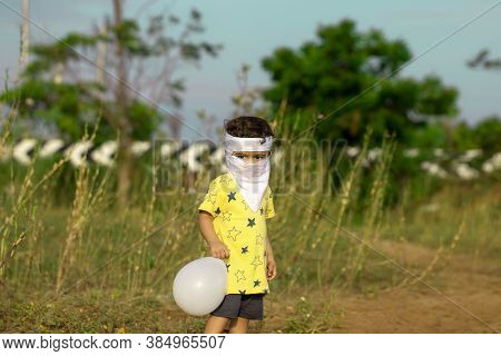 To Avoid The Corona Virus, A Little Child Covered With A Mouth Full Of Homemade Face Masks Played Wi