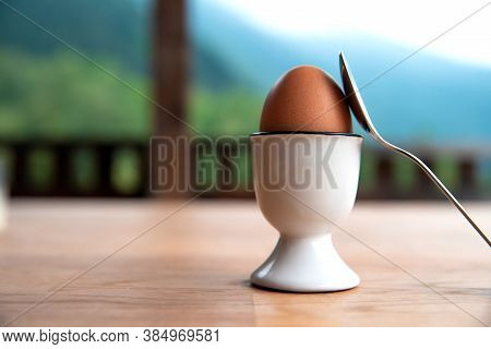 Boiled Egg In Eggcup On Wooden Table Outside, Breakfast Eggin White Egg Cup