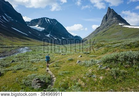 Hiking in Swedish Lapland. Man trekking alone in northern Sweden. View of Nallo mountain, Arctic nature of Scandinavia in summer day