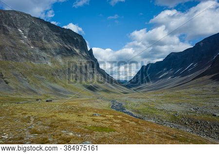 Picturesque Swedish Lapland landscape. Nallo mountain hut in northern Sweden. Arctic environment of Scandinavia in summer sunny day with fluffy clouds