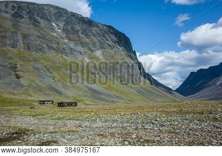 Nallo mountain hut in northern Sweden. Picturesque Swedish Lapland landscape. Arctic environment of Scandinavia in summer sunny day with fluffy clouds
