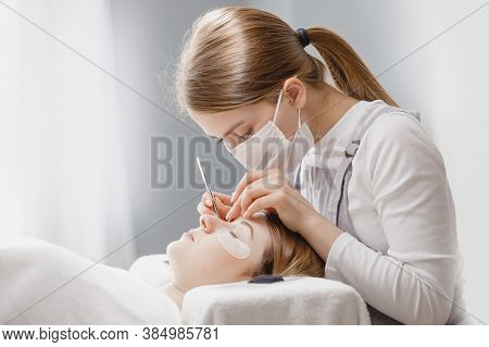 Master Tweezers Sets Fake Lashes On Beautiful Woman. Eyelash Extension Procedure